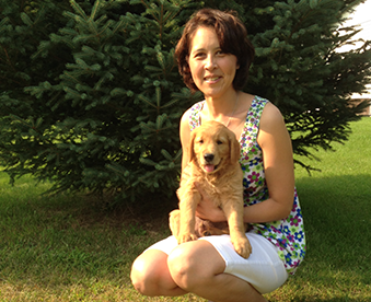 outdoor photo of woman holding her golden retriever puppy on Gotcha Day