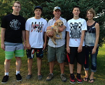 outdoor photo of family and their newly adopted golden retriever puppy