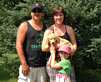 outdoor photo of family with their golden retriever puppy